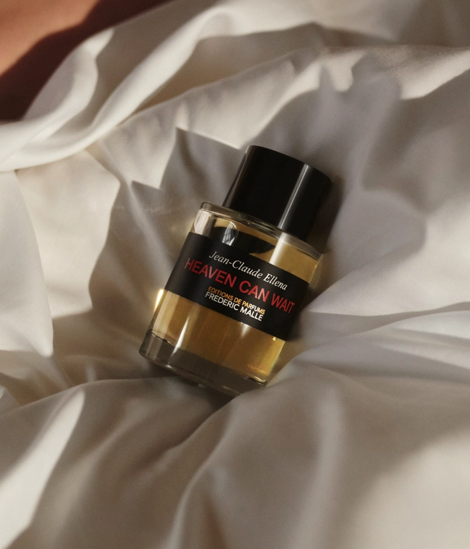 Frederic Malle Perfume Bottle on bed sheets 