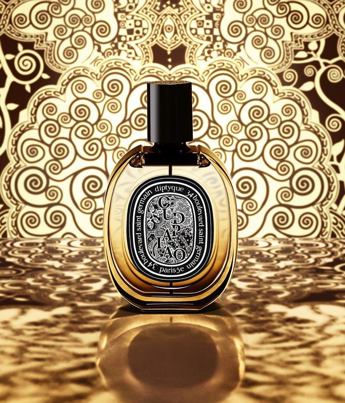 Circular Oud Palao Diptyque bottle in front of orante middle eastern gold backdrop